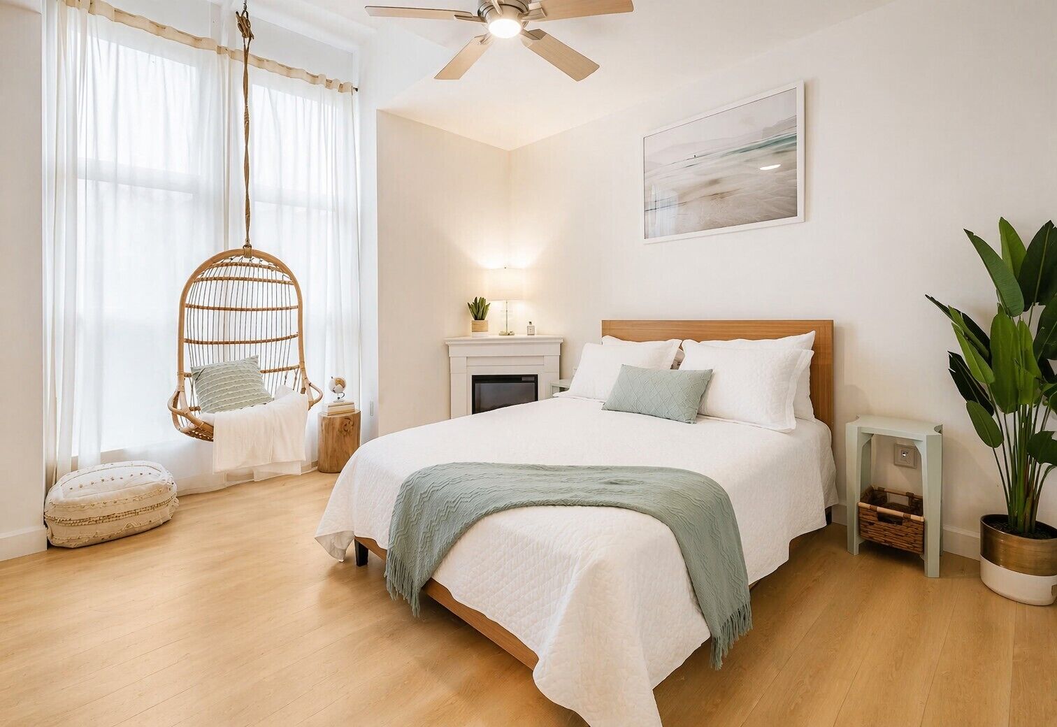 A bedroom with a bed, a hanging chair, a fireplace, and a large window.