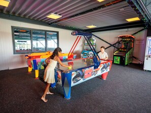 An indoor arcade with various gaming machines, including a racing game and a claw machine. - Sunset Comfort by Interhome (Scherpenisse)