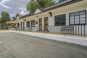 A building with a covered porch, multiple windows, and a gated entrance.