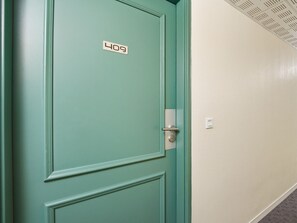 Eine türkisblaue Tür mit einer Nummernschild, auf der '409' steht, und einem Türgriff.