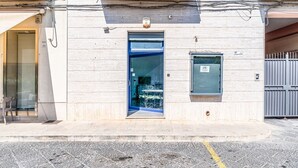A building with a blue door, a small window, and a metal gate. - Al Portico - In the Heart of Avola (Avola)