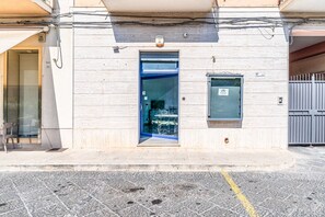 Ein Gebäude mit einer blauen Tür, einem kleinen Fenster und einem Metallgitter.