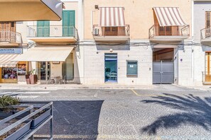 A street with buildings, a shop, and a café. - Al Portico (Avola)