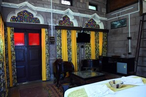 A room with a bed, a television, a desk, and a chair. - The Thikana Heritage  (Jodhpur)