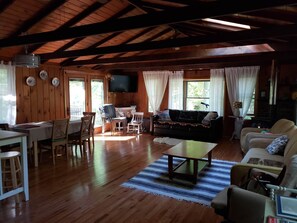 A wooden interior with a dining area, sofa, and fireplace. - Cozy 3-bedroom cabin in soothing Pocono Lake with AC, pools, lake, tennis court (Pocono lake)