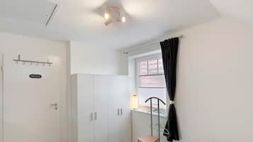 Ett rum med en vit garderob, en dörr med en skylt som säger ”PRIVAT”, ett fönster med en gardin och en stol.