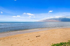 Une plage avec un ciel dégagé et une mer calme.