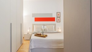A modern bedroom with a bed, bedside tables, and a nightstand. - Nineteen by Rent All Como (Como)