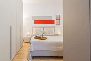 Ein modernes Schlafzimmer mit einem Bett, Nachttischen und einem Beistelltisch.