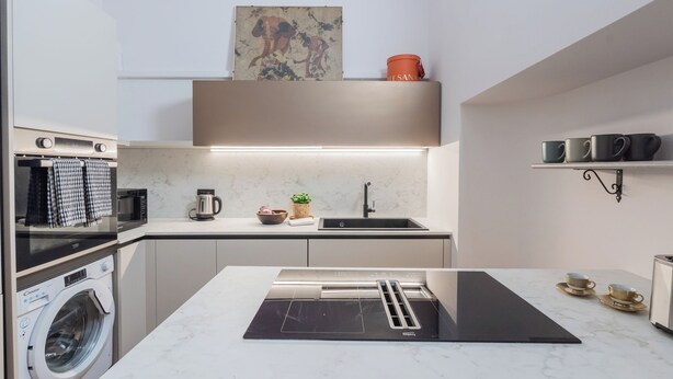 A compact kitchen with a built-in washing machine, a microwave, a kettle, and a sink. - Churchkey by Rent All Como (Como)