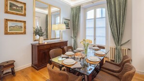 A dining room with a glass table set for four, surrounded by cushioned chairs. - Churchkey by Rent All Como (Como)