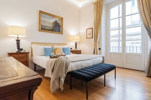 A hotel room with a bed, bedside tables, a bench, a window with curtains, and a painting on the wall. - Churchkey by Rent All Como (Como)