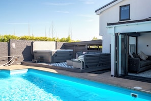 Ein Schwimmbecken mit Liegestuhl und einem überdachten Stauraum.