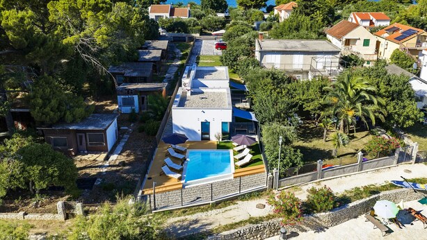 A residential area with a swimming pool, surrounded by trees and houses. - Beachfront Almare Retreat (Sukošan)
