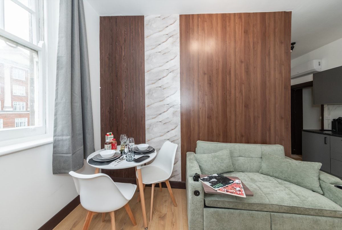A modern living space with a dining area, a sofa, and a marble accent wall.