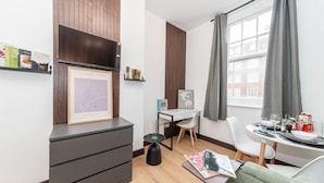 Une chambre moderne équipée d’un bureau, d’une chaise et d’un coin repas aménagé pour deux personnes.