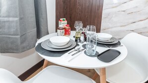 Une table à manger dressée avec des assiettes, des couverts, des verres et des condiments.
