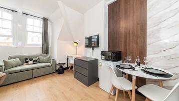 A compact living space with a kitchenette, a dining area, and a sofa.