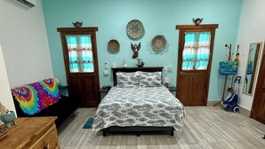 Une chambre à coucher avec un lit, une commode en bois et un ventilateur de plafond.
