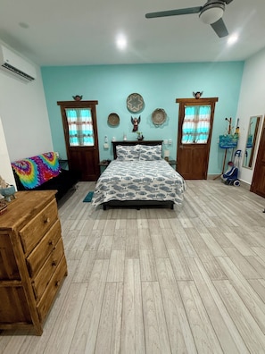 A bedroom with a bed, wooden dresser, and a ceiling fan. - Centrally located walking distance from restaurants, Mercadito, etc... (Isla Mujeres)
