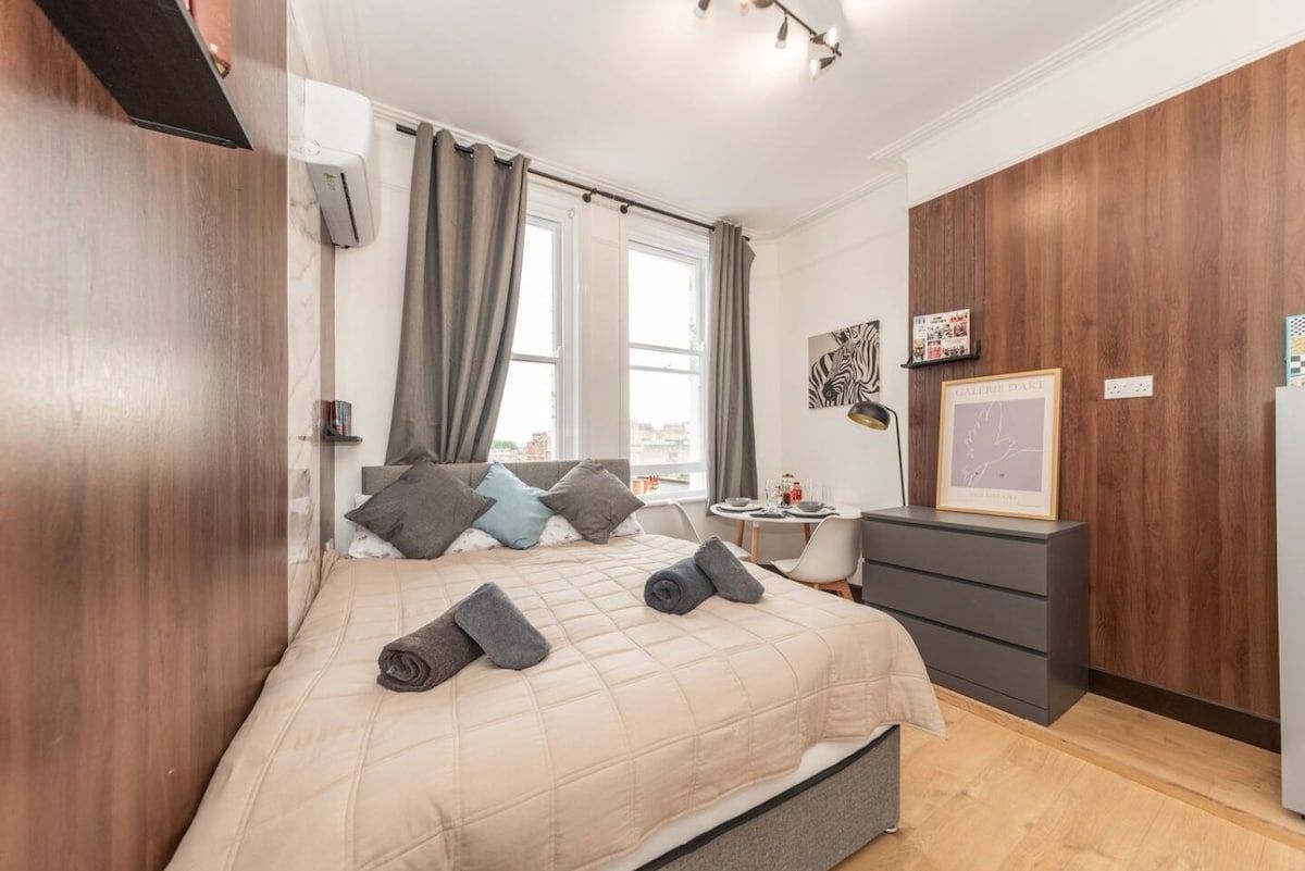 A bedroom with a bed, bedside table, and a dresser.