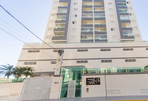 A multi-story building with a glass entrance and a staircase leading to the entrance. - Apt with Balcony & Parking 300m | Vila Tupi Beach (Praia Grande)