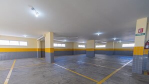 A multi-level parking garage with yellow and blue tiled walls, concrete floors, and emergency exit signage.