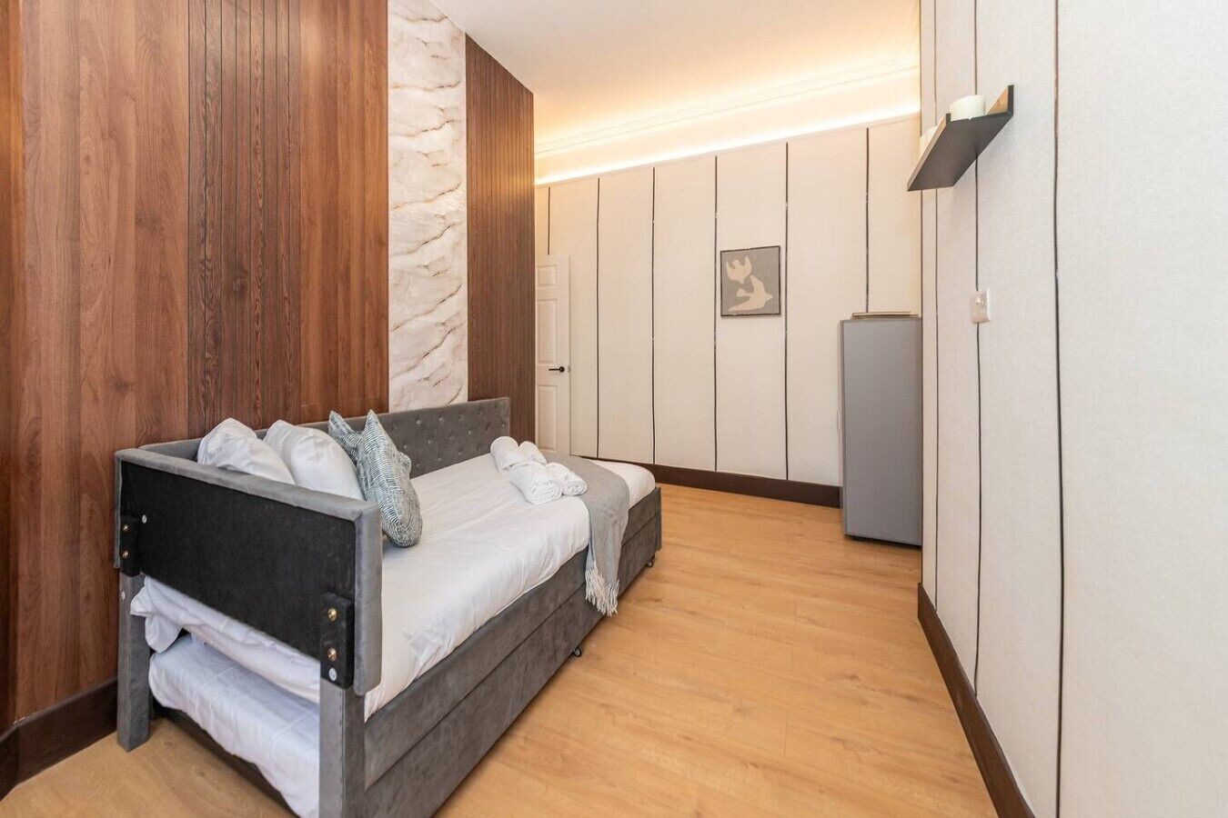 A bedroom with a bed, a wardrobe, and a small cabinet.