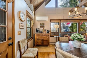 Une cuisine chaleureuse avec des meubles en bois, un coin café et un espace repas comprenant une table et des chaises.