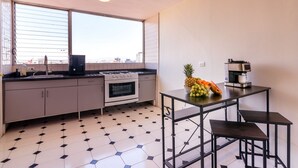 Una cocina moderna con estufa a gas, horno y cafetera sobre una mesa.