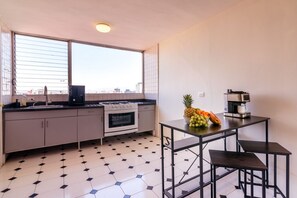 Eine moderne Küche mit Gaskochfeld, Backofen und einer Kaffeemaschine auf einem Tisch.