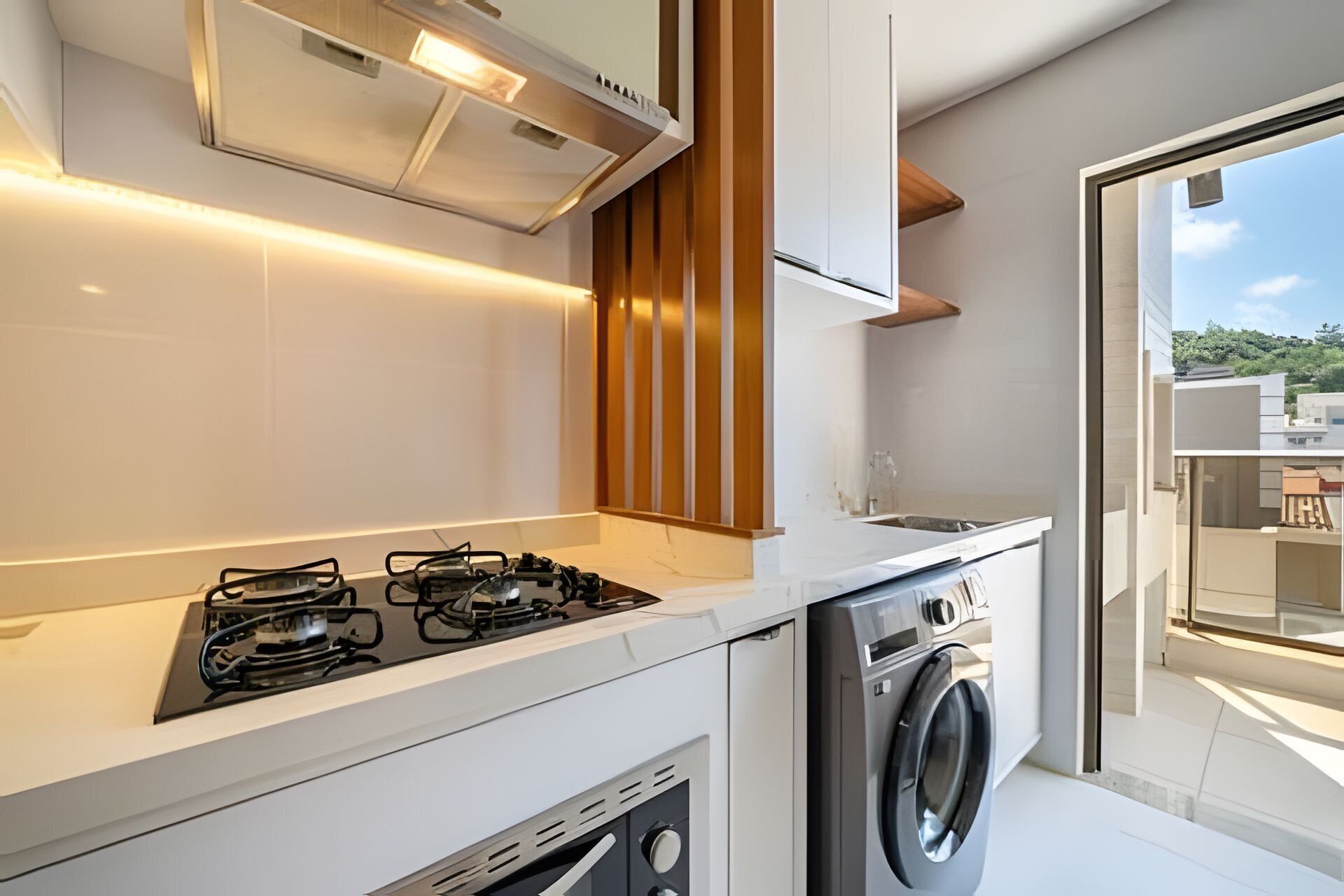 Una cocina moderna con estufa a gas, horno empotrado y lavadora.