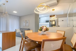 Un comedor moderno con una mesa de madera, sillas y un florero.