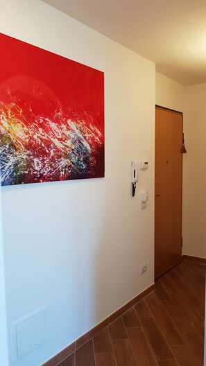 A hallway with a red abstract painting, a phone, and a door. - CASA MIA Guesthouse (Firenze)