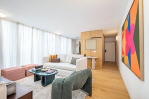 A modern living room with a sofa, coffee table, and a painting on the wall. - Aspasios Formosa Collection (Porto)