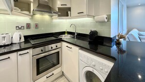Uma cozinha moderna com forno embutido, máquina de lavar roupa e cafeteira.