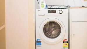Máquina de lavar com carga frontal, com etiqueta de classificação da água e etiqueta de classificação energética.