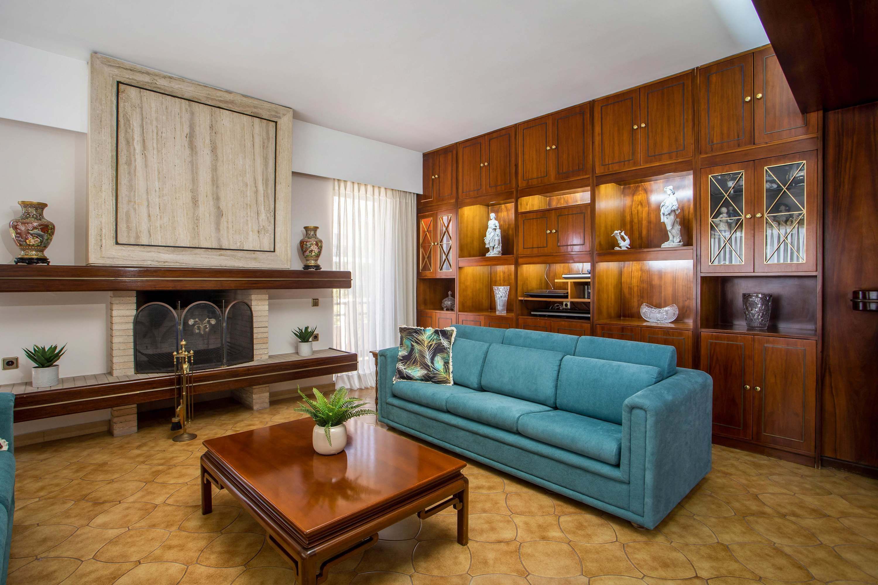 A living room with a sofa, coffee table, fireplace, and wooden cabinets with decorative items. - Elegant Spacious Apartment in Rhodes With Balcony (Rhodes)