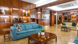 A spacious living area with a blue sofa, wooden cabinets, and a coffee table. - Elegant Spacious Apartment in Rhodes With Balcony (Rhodes)