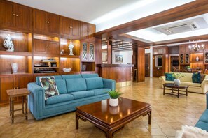 A spacious living area with a blue sofa, wooden cabinets, and a coffee table. - Elegant Spacious Apartment in Rhodes With Balcony (Rhodes)