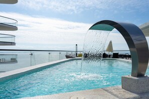 A pool with a water feature, glass balustrades, and a view of the sea. - Beachfront Luxury at Tizate Pool Concierge (La Cruz de Huanacaxtle)