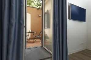 A room with a sliding glass door leading to an outdoor patio area with a table and chairs. - San Francesco Ripa 1 - Meo Patacca Vibrant Nest (Rome)