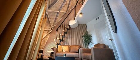 A modern interior with a staircase, a sofa, and a coffee table.