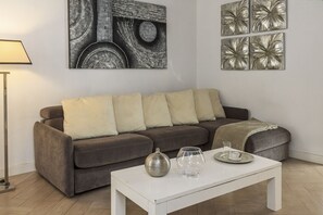 Ein Wohnzimmer mit einer Couch, einem Couchtisch und Wandbildern.