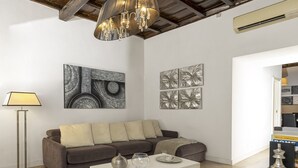A modern living room with a sofa, coffee table, and artwork on the walls. - San Francesco Ripa 3 - Trilussa 3BR Group Family Home (Rome)