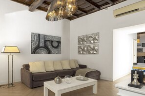 Ein modernes Wohnzimmer mit Sofa, Couchtisch und Kunstwerken an den Wänden.