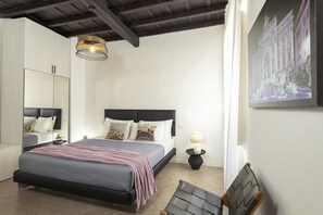 A bedroom with a bed, bedside table, lamp, and a large mirror. - San Francesco Ripa 4 - Lorenza 3BR Group Family Home (Rome)