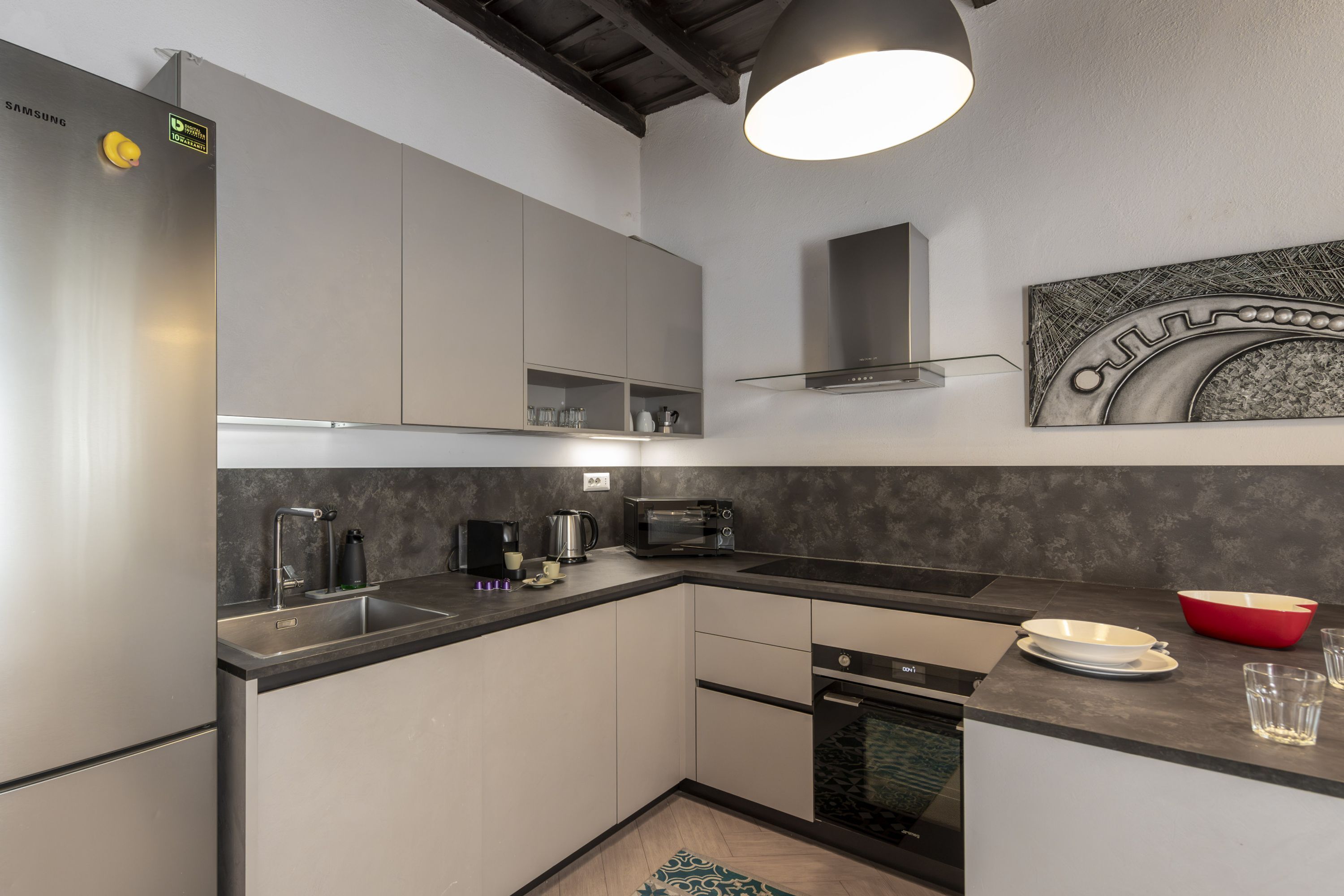 Una cocina moderna con electrodomésticos de acero inoxidable, horno empotrado y microondas.