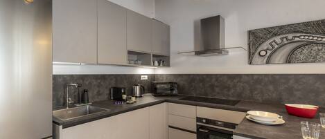 Una cocina moderna con electrodomésticos de acero inoxidable, horno empotrado y microondas.