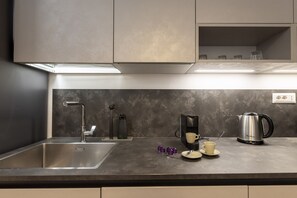 A modern kitchen with a stainless steel sink, a coffee maker, and a kettle on the counter. - San Francesco Ripa 4 - Lorenza 3BR Group Family Home (Rome)